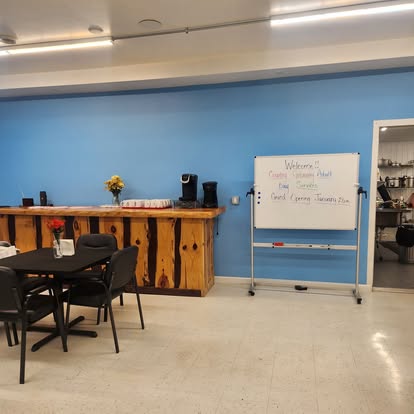 Activity room with whiteboard, dining tables, and natural light